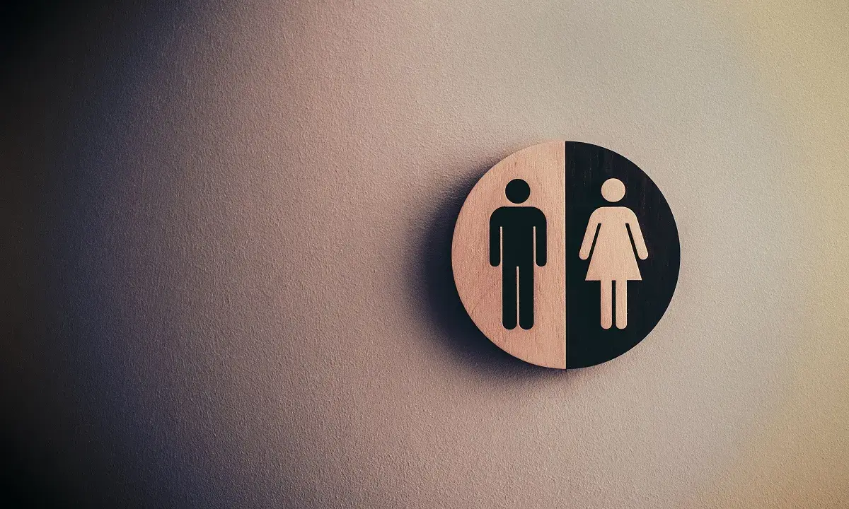 Symbol płci na tle ściany. Fizjoterapia uroginekologiczna dla każdego.