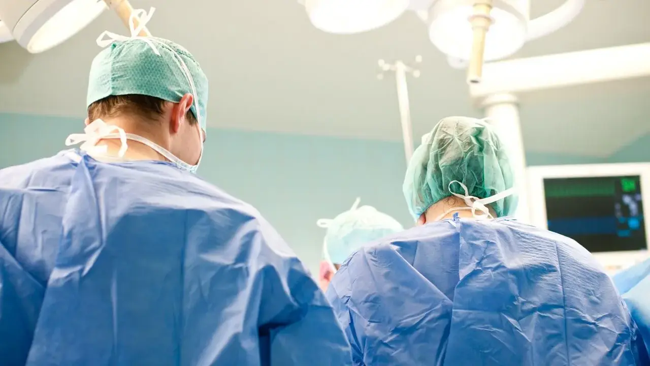 Chirurdzy w zielonych czepkach i niebieskich fartuchach przygotowują się do klasycznej operacji prostaty.