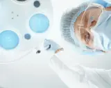 Chirurg w masce i okularach pochyla się nad pacjentem, przygotowując zalecenia po operacji prostaty.