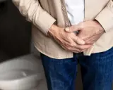 Mężczyzna trzyma się za podbrzusze, zastanawiając się, jakie badania na prostate są najlepsze.