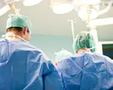 Chirurdzy w zielonych czepkach i niebieskich fartuchach przygotowują się do klasycznej operacji prostaty.