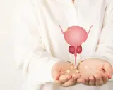 Dłonie trzymające symbol prostaty, nawiązanie do łagodnego przerostu prostaty u psa.