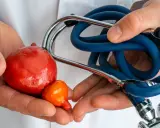 Dłonie lekarza trzymają model pęcherza i prostaty. Stetoskop symbolizuje troskę o zdrowie i prawidłową funkcję prostaty.