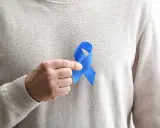 Mężczyzna trzyma niebieską wstążkę symbolizującą świadomość raka prostaty. Rozważamy usunięcie prostaty skutki.