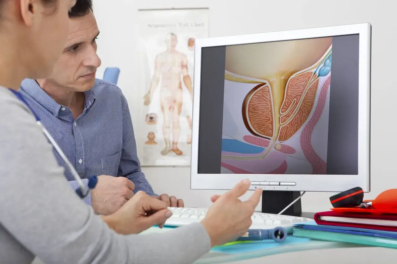 Lekarz omawia z pacjentem schemat prostaty, wyjaśniając przebieg zabiegu elektroresekcji prostaty.